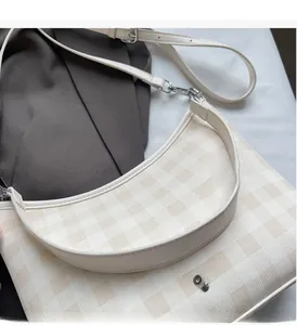 Gros plan sur le sac dumpling vichy crème avec logo argenté et détails de bordure en cuir