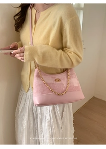 Vue détaillée du sac hobo rose avec chaîne dorée et finition en tissu texturé