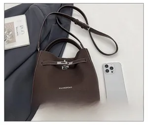 Flat lay of vintage dark brown pebble leather handbag with silver twist lock detail