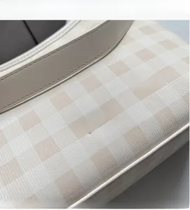 Détail du tissu à carreaux et logo argenté sur le sac seau minimaliste beige
