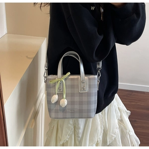 Détail du sac seau à carreaux gris argenté avec pendentif tulipe sur tenue