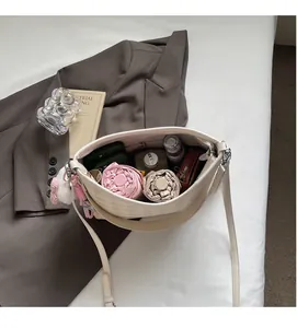 Intérieur spacieux d'un sac bandoulière crème matelassé avec téléphone et objets