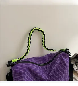 Close-up of purple plaid tote with neon green and black braided rope handles