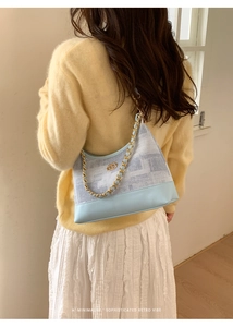 Détail du sac porté épaule en jean bleu clair avec chaîne et motifs géométriques rétro