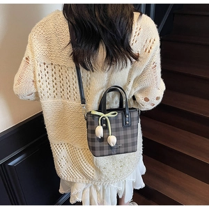 Crossbody view of a gingham mini tote bag with tulip pendant and ribbon detail