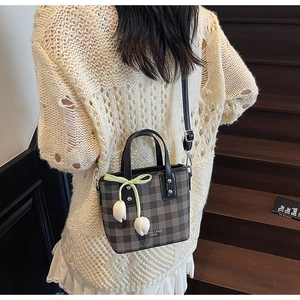 Détail du sac seau à carreaux gris avec breloques tulipes et lettrage stylé