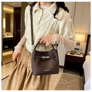 Detailed view of dark brown litchi pattern leather bucket bag with silver metal twist lock