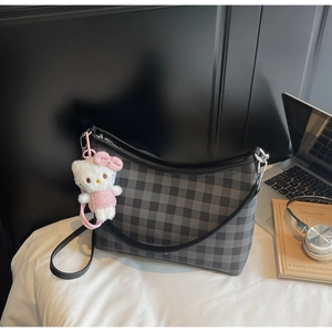 Détail du sac cabas à carreaux gris avec un charm peluche et des finitions argentées