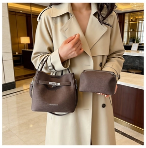Detail of dark brown lychee pattern leather bucket bag with silver metal lock and mini pouch