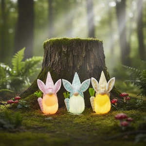 Trois gnomes de Pâques lumineux avec oreilles de lapin et carottes en forêt