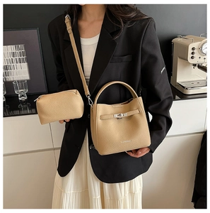 Detail of camel lychee leather bucket bag with top handle and matching small pouch