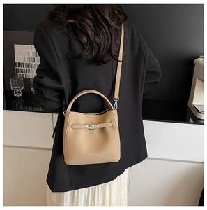 Detail of khaki bucket bag with lychee pattern leather and silver metal twist lock