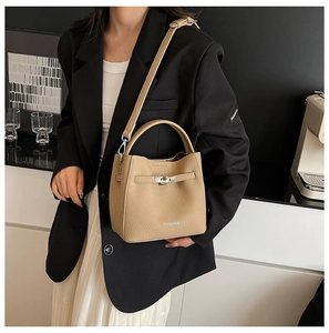 Detail of khaki bucket bag with silver metal swivel lock and adjustable shoulder strap