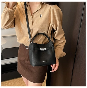 Detail of black pebbled leather bucket bag with silver twist lock and brand logo