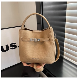 Detail of light brown lychee grain leather bucket bag with silver metal swivel lock buckle
