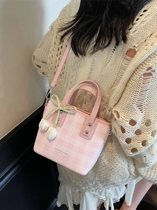 Sac seau à carreaux roses avec breloques tulipes et bandoulière porté par un mannequin