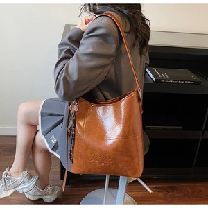 Detail view of large brown faux leather tote with vintage texture and MKXO logo