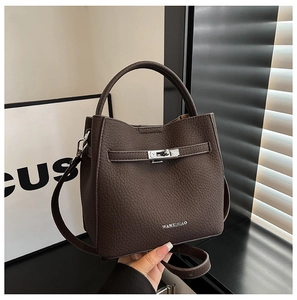 Detail view of dark brown bucket bag featuring lychee texture and silver metal clasp
