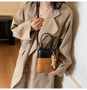 Detail of cross-body bucket bag with brown suede quilting and colorful wood beads