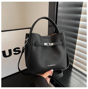 Detail of black bucket bag featuring lychee grain leather texture and silver buckle