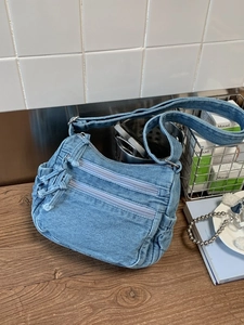 Retro denim shoulder bag in light blue wash with fringe and double zipper detail