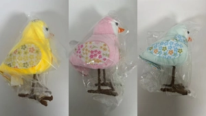 Detailed view of colorful plush Easter birds with floral wings and branch bases