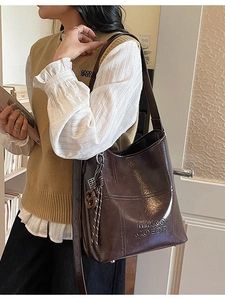 Deep brown oil-wax leather bucket bag with tassels for women, spacious shoulder tote style