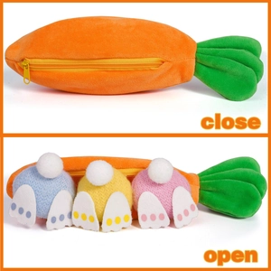 Detalle de bolsa de zanahoria de felpa con cremallera que muestra tres colas de conejo de colores