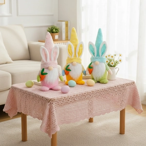 Tre gnomi pasquali colorati con orecchie da coniglio e carote per decorazioni da tavolo