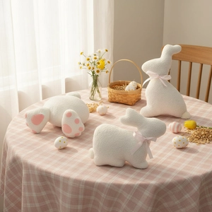 Three white plush bunny pillows with pink bows as Easter holiday home decorations