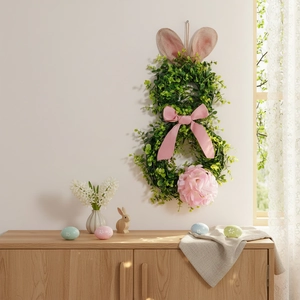 Detailed view of an Easter rabbit wreath with green faux leaves and pink silk flowers