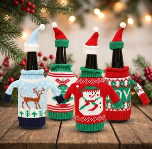Detail view of 4-pack knitted Christmas wine bottle sweaters with hats on wood surface