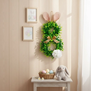 Easter bunny wreath with green foliage, pink ears and golden bow for home wall decor