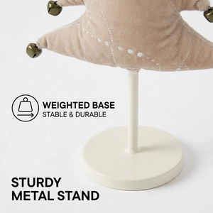 Detail of velvet Christmas tree with golden bells and stable weighted metal base