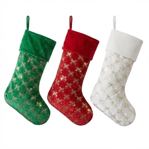 Three sequined velvet Christmas stockings in red green and white for tree decoration