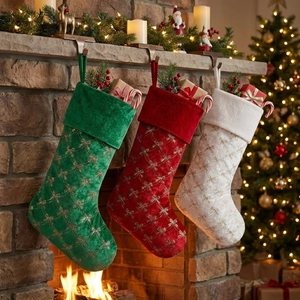 Three sequined bow Christmas stockings in red, white and green on a festive fireplace mantle