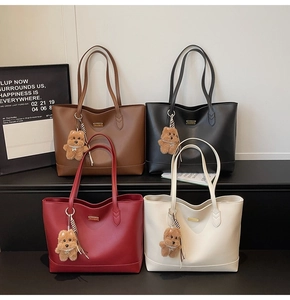 Four chic tote bags in brown, black, red, and beige with plush bear charms