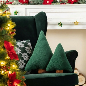 Détail de deux coussins en forme de sapin de Noël en tissu sherpa vert sur un canapé