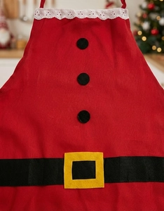 Detail of red Santa apron with white lace collar and decorative black buttons