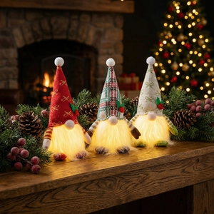 Dettaglio di tre gnomi di Natale luminosi con nasi a LED su sfondo festivo caldo