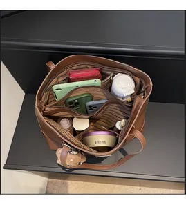 Top view showing spacious interior with multi-compartment lining of brown leather tote bag