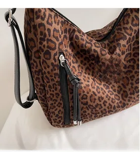 Close-up of leopard print crossbody bag featuring smooth metal zippers and functional pockets