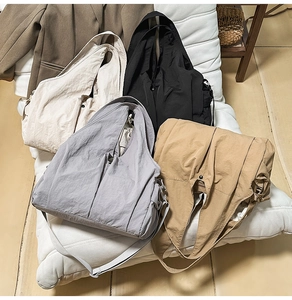 Macro shot showing four large nylon tote bags in beige, black, gray and khaki color options
