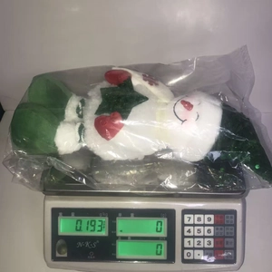 Detail view of a telescopic snowman doll with sequins on a scale weighing 193 grams