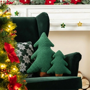 Christmas tree shaped plush pillows in green sherpa fabric on a cozy velvet armchair