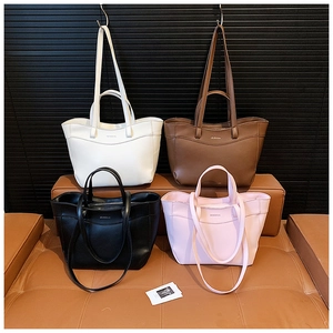 Detail view of large tote bags in white, brown, black, and pink with lychee grain texture
