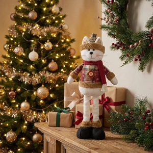 Detail showing a plush Christmas cat doll in festive plaid outfit on a wooden surface
