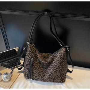 Macro shot of stylish leopard print hobo bag with leather tassels and silver hardware detail