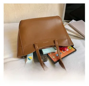 Spacious brown tote bag showing interior storage for a tablet, phone, and card holder