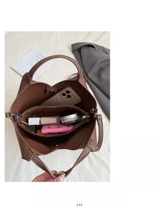 Vue intérieure du sac seau en cuir marron foncé avec compartiments de grande capacité